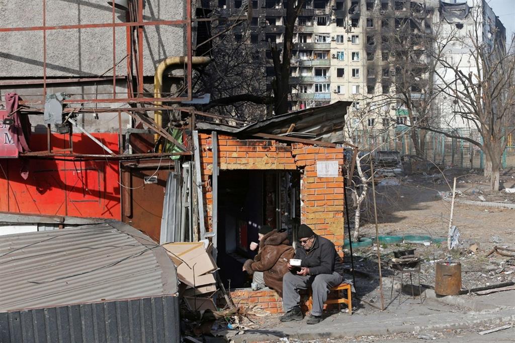 Abitanti di Mariupol organizzano il pranzo fuori di un edificio danneggiato